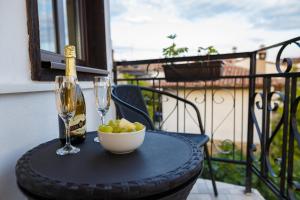 a table with a bottle of wine and a bowl of grapes at Apartment Zdravets, in the heart of the old city in Veliko Tŭrnovo