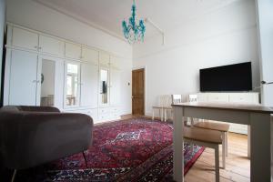 uma sala de estar com uma mesa e uma televisão de ecrã plano em Carlton House em Newport