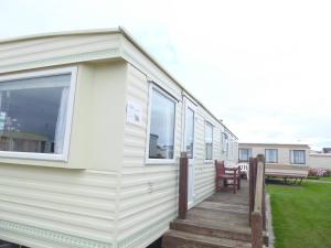 a mobile home with a porch and a deck at Beachside, Family-friendly, WiFi, 8 berth Caravan 158 in Ingoldmells