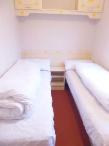 two beds sitting next to each other in a room at Beachside, Family-friendly, WiFi, 8 berth Caravan 158 in Ingoldmells