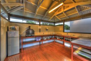 a large kitchen with a refrigerator and a counter at Fraser Coast Top Tourist Park in Hervey Bay