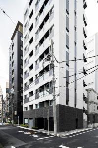 a tall white building on a city street at Section L Ginza East in Tokyo