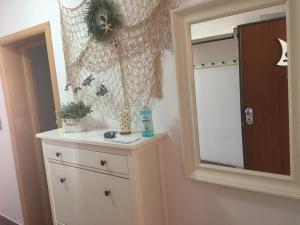 ein Badezimmer mit einer Kommode und einem Spiegel in der Unterkunft Apartments San Marino in Novi Vinodolski