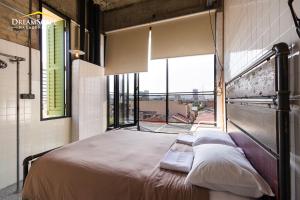 a bed in a room with a large window at Belakang KongHeng By DreamScape in Ipoh