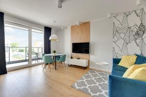 a living room with a blue couch and a table at Wave Apartments - Świętej Barbary 11/60 in Gdańsk