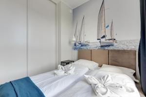 a bedroom with two beds with sailboats in the background at Wave Apartments - Świętej Barbary 11/60 in Gdańsk