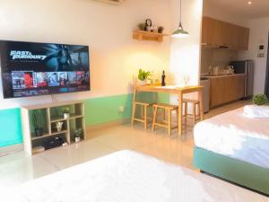 - un salon avec un lit et une télévision murale dans l'établissement KSL City Mall 4-6pax Netflix-SmartTV 65inch, à Johor Bahru