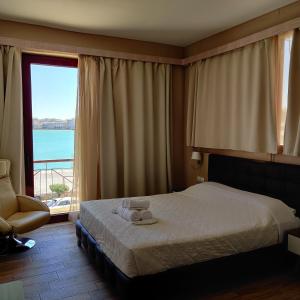 City Point Chios في خيوس: غرفة نوم بسرير ونافذة كبيرة