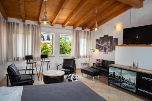 a living room with a television and a table and chairs at Dolce Studio Apartmani in Rovinj