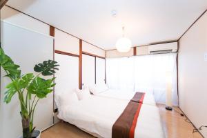 a bedroom with a bed and a large window at Yokkaichi Nishishinchi Hotel in Yokkaichi
