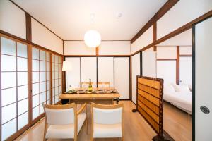 四日市市にあるYokkaichi Nishishinchi Hotelのテーブル、椅子、ベッドが備わる客室です。
