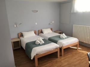 a room with two beds with towels on them at Centre Jean XXIII in Annecy
