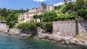 a river with buildings on the side of a hill at Seaside Apartment Volosko on the beach in Opatija