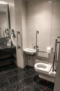 a bathroom with a toilet, sink, and bathtub at Crowne Plaza London Heathrow T4, an IHG Hotel in Hillingdon