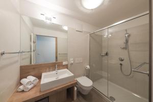 ein Bad mit einem Waschbecken, einem WC und einer Dusche in der Unterkunft Apparthotel Zunneler in Schenna