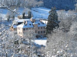 a large building in the snow with snow covered trees at Chambres d'Hôtes Les Tapies in Agen dʼAveyron