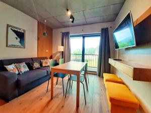un soggiorno con un tavolo e un divano di Złoty Widok Ski & Spa a Szczyrk Altre 109 foto