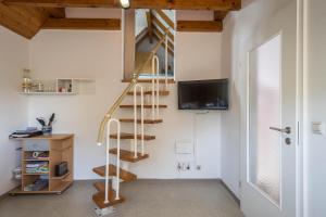 Cette chambre comprend un escalier en colimaçon et une télévision. dans l'établissement Ferienwohnung Konrad Schielin, à Lindau