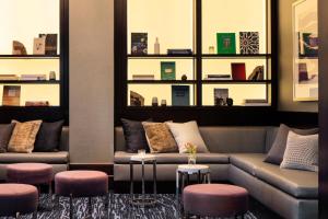 a living room with two couches and two stools at Kimpton Tryon Park Hotel, an IHG Hotel in Charlotte