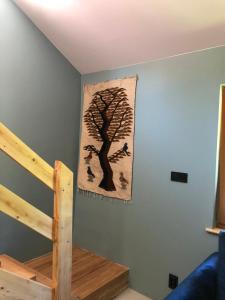 a painting of a tree on a wall next to a staircase at BIELICE Chatka Trapera & Co in Stronie Śląskie