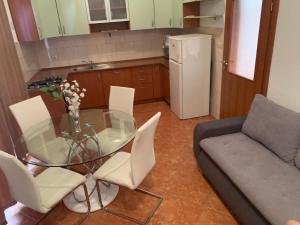 eine Küche mit einem Glastisch, Stühlen und einem Sofa in der Unterkunft Apartment Lena in Kaštela