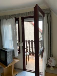 Drzwi na balkon z telewizorem w obiekcie WhiteHouse Alsoors w Alsóörs