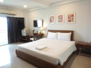 a bedroom with a large white bed and a desk at The Ivory, Suvarnabhumi Airport in Lat Krabang