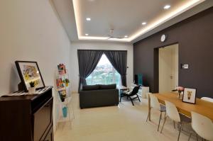 uma sala de estar com um sofá e uma mesa em Comfy 2BR TriTower Suite next to JB CIQ, JBCC & Capri em Johor Bahru