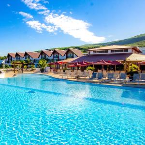 ein großer Pool mit Stühlen in einem Resort in der Unterkunft Akoya Hotel & Spa in La Saline-Les-Bains
