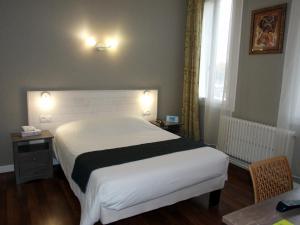 Rúm í herbergi á Logis Hotel L'Occitan 2 étoiles