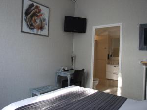 Rúm í herbergi á Logis Hotel L'Occitan 2 étoiles