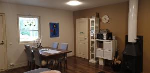 a dining room with a table and a clock on the wall at Villa Tammikallio Guest House, near the airport - Kodikas vierasmaja Tuusulassa in Tuusula