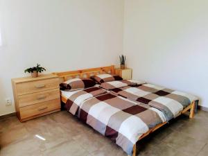 a bedroom with a bed and a wooden dresser at Do zahrady in Liberec