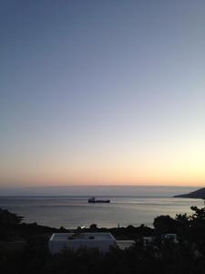 聖佩特羅斯的住宿－Villa Maniati Studios，日落时分在海洋中的集装箱船