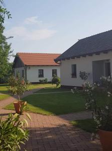 a house with a yard with a lawn at Tóth Vendégház és Apartmanház Újfehértó in Újfehértó