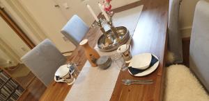 a wooden table with plates and a vase on it at Villa Tammikallio Guest House, near the airport - Kodikas vierasmaja Tuusulassa in Tuusula