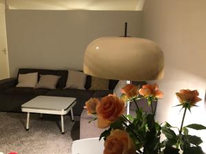 a living room with a couch and a lamp and roses at Savina City Centre Apartment Near Beach, Station and Shops in Zandvoort