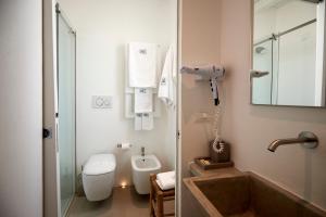 a bathroom with a toilet and a sink and a shower at Musae Relais & SPA in Polignano a Mare