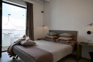 a bedroom with a bed with pillows and a window at Musae Relais & SPA in Polignano a Mare