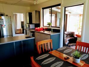 a kitchen with a table and a dining room at Hot Tub at Pukeko Cottage in Geraldine