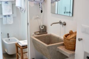 a bathroom with a large tub and a sink at Musae Relais & SPA in Polignano a Mare