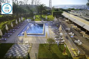 an overhead view of a pool with chairs and umbrellas at Novotel Porto Gaia in Vila Nova de Gaia