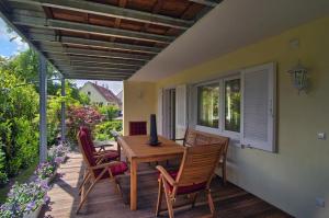 a patio with a wooden table and chairs on a deck at Ferienwohnung an der Elz in Emmendingen