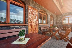 a porch with a wooden bench and a window at Penzión Patrik in Ždiar +35 photos