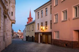 un callejón en una ciudad con edificios y una iglesia en Lucerna - dům s duší Příbor en Příbor