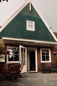 Casa con techo verde, sillas y mesa en Slapen bij Jesse, en Broek in Waterland