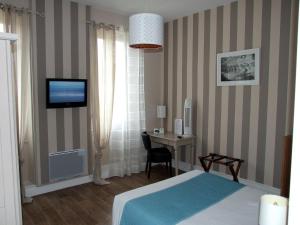 Rúm í herbergi á Logis Hotel L'Occitan 2 étoiles