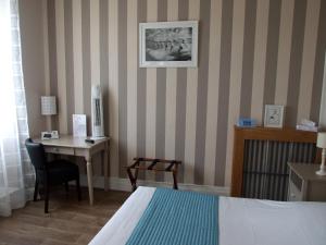 Rúm í herbergi á Logis Hotel L'Occitan 2 étoiles