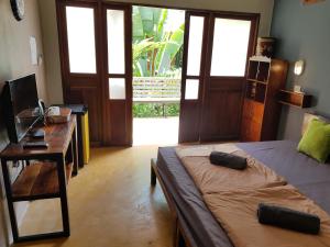 a bedroom with a bed and a desk with a desk at Slow Life Sabaidee Pai in Pai