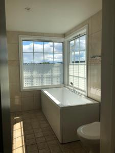 a bathroom with a tub and a toilet and a window at Villa Sole, Trysil in Trysil +54 photos